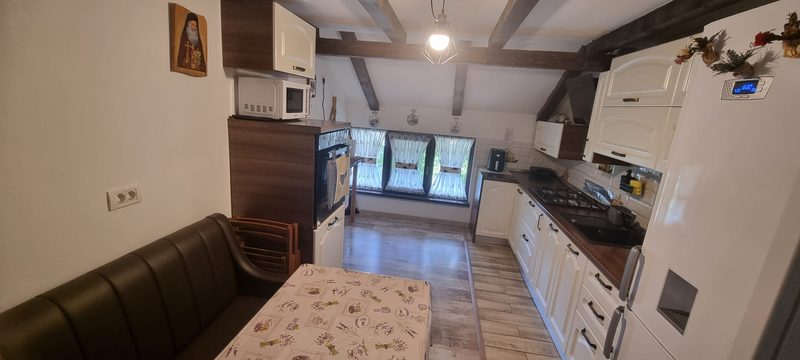 Bucătăria Casei David cu banchetă de piele, masă și blat de lucru generos