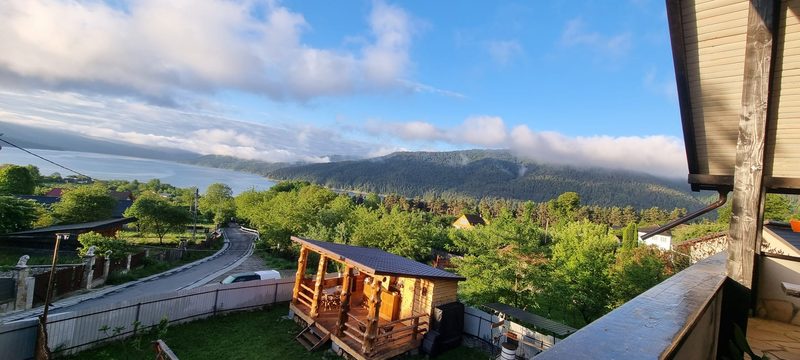Curtea Casei David, cu sauna din lemn, gazon verde și priveliștea spre lac